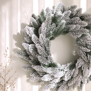 Realistic Christmas wreath with green pine branches and thick artificial white snow decor