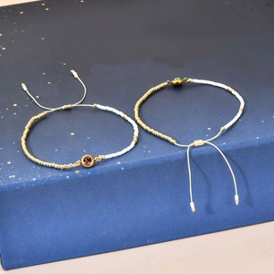 Adjustable rice bead bracelets with purple and green zircon on a gift box