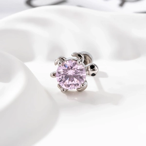 Silver turtle cartilage stud earring with pink zircon stone on white fabric