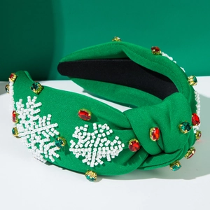 Detail eines grünen Knotenstirnbands mit handgefertigten Perlen-Schneeflocken und Strass