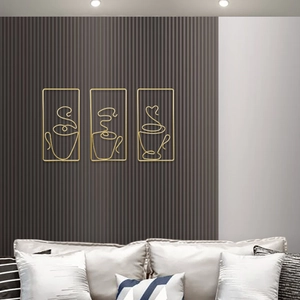 Three-piece set of golden Nordic wire coffee cup wall art hanging on a textured grey wall