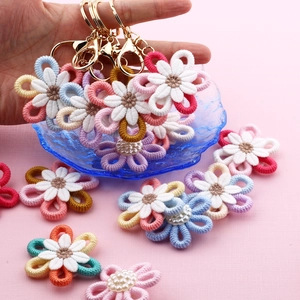 Detailed view of colorful handmade crochet flower keychains with gold metal rings