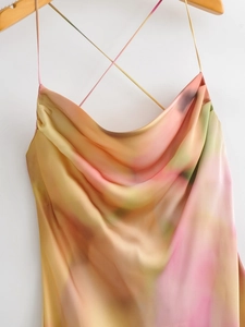 Detail of cross straps and abstract watercolor print on smooth satin long dress