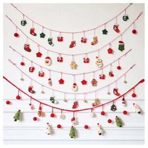 Detail of wool felt Christmas ornaments including Santa, snowman and gingerbread man on strings