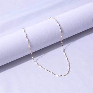 Detail of a thin gold chain necklace with white enamel olive beads for women