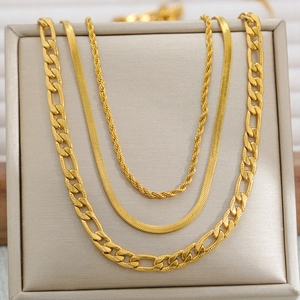 Detail of layered gold stainless steel necklaces featuring Cuban and snake chain styles