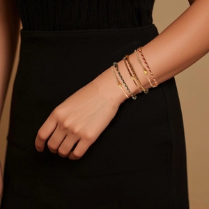 Minimalist hand-woven rope bracelet set with heart star and cross charms on wrist