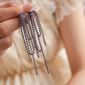 Detail of vintage purple crystal tassel earrings with dark metal and layered rhinestones