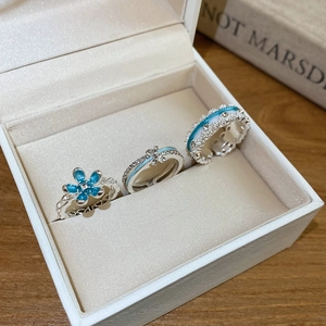 Macro detail of three elegant blue enamel rings with inlaid crystals in a jewelry box