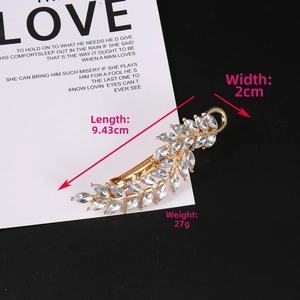 Detail of leaf hair clip showing length 9.43cm and width 2cm with rhinestones