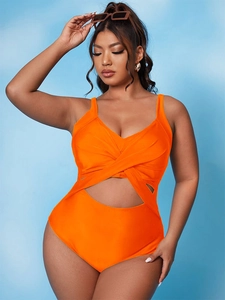 Detail of bright orange one-piece swimsuit with twist-knot front and waist cutout design