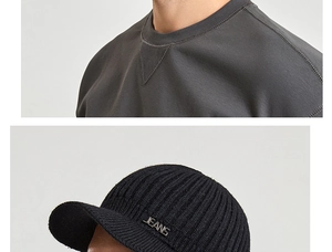 Macro detail of men's knitted winter hat with JEANS metal logo and ribbed cotton sweater
