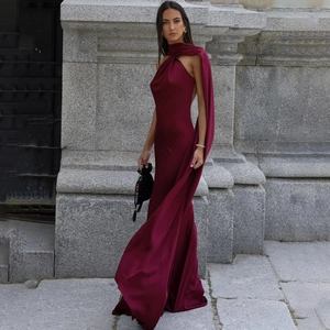 Macro detail of wine red silk satin dress showing elegant backless design and cape