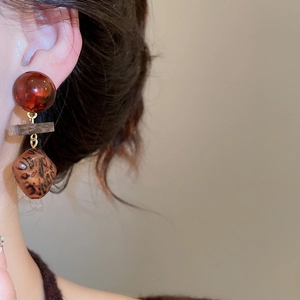 Gros plan de boucles d'oreilles cœur vintage en bois avec détails léopard géométriques