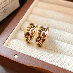 Close-up of vintage leopard print C-shape earrings with gold finish in a velvet box