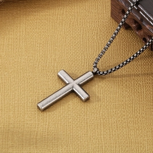 Detailed view of vintage stainless steel cross pendant on a classic box chain