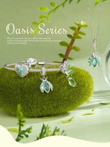 Detailed close-up of S925 silver charm bracelet with green crystals on natural moss