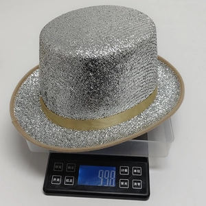 Detailed view of silver sequin top hat on a scale showing a weight of 99.8g