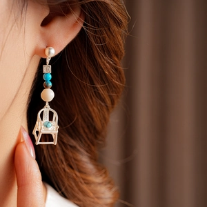 Close-up of vintage silver chair earring with turquoise beads on a female model