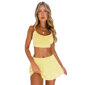 Two-piece yellow summer set featuring a cropped halter top and tiered ruffle mini skirt