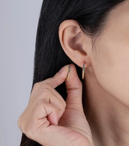 Close-up of rainbow cubic zirconia hoop earrings in 14k gold plated silver on model