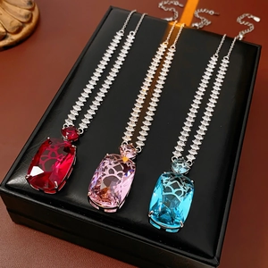 Detailed view of red, pink, and blue square zircon pendant necklaces on display