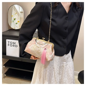 Close-up of pink floral silk bag with gold chain and elegant long hanging tassels