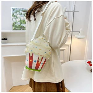 Lifestyle shot of a quirky cupcake-shaped crossbody bag worn by a model in a home setting