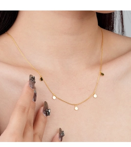 Macro view of gold minimalist choker necklace with five polished round disk pendants