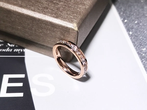 Macro detail of rose gold titanium steel ring with sparkling pave set cubic zirconia crystals