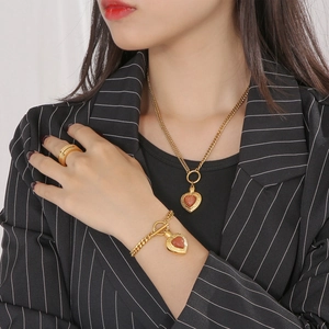 Vue détaillée de pendentifs cœur avec œil-de-chat sur collier et bracelet dorés de luxe