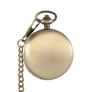 Close-up of vintage bronze pocket watch case with hollow gear design and metal chain
