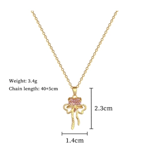 Detailed specs of gold necklace with pink heart gem and crystal bowknot pendant