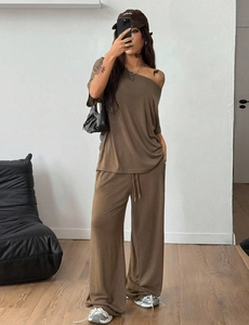 Detalle del conjunto de top con hombros descubiertos marrón oliva y pantalones de pierna ancha