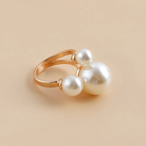 Detail of three white pearls set on a golden metal ring base with a trendy French design