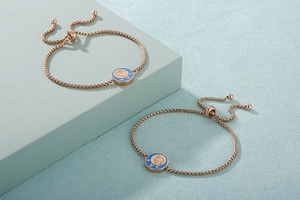 Dettagli di bracciali regolabili in oro rosa con ciondoli zodiacali in smalto blu