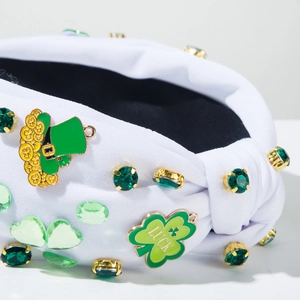 Detail of St. Patrick's Day white knotted headband with green rhinestones and clover lucky charm
