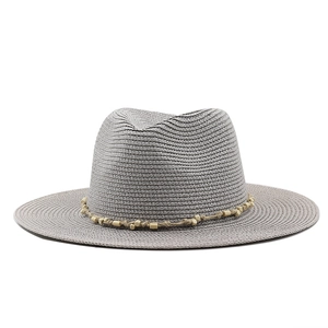 Close-up of bohemian jazz hat featuring straw braid texture and wooden bead band detail