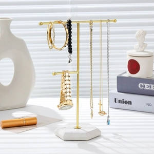 Golden T-bar jewelry stand with white marble base for organizing necklaces and bracelets