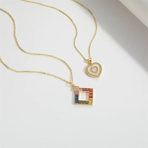Detail of gold heart pendant with crystals and square rainbow zircon necklace charm