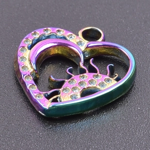 Macro shot of rainbow-colored heart pendant with moon and sun cutout and inlaid zircons