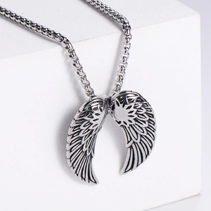 Detailed close-up of retro silver stainless steel angel wing pendant with square link chain