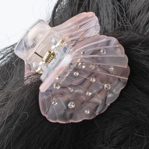 Pince à cheveux rose en forme de coquillage en acrylique avec strass sur cheveux noirs