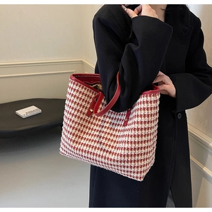 Red houndstooth tote bag shown held by a model to display its large capacity and style