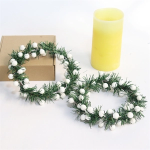 Detail of Christmas candle rings featuring green pine needles and white berries