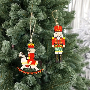 Wooden Nutcracker ornaments on horse and drum, hanging on a decorated Christmas tree
