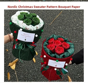 Detail of Christmas bouquet wrap with red and green knit texture and plush pom-pom trim