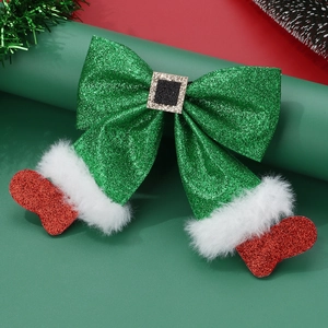 Close-up of glittery Christmas elf bow hair clip with red sequin boots and soft fur trim