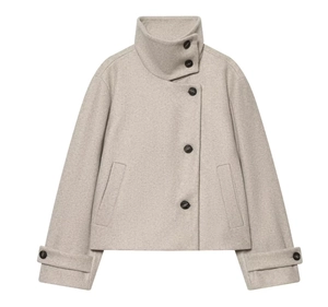 Détail d'un manteau en laine beige avoine avec col montant et fermeture asymétrique