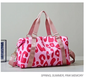 Detail of pink leopard print travel bag with durable nylon texture and metal hardware hooks
